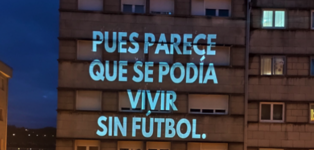 Proyección del mensaje "pues parece que se podría vivir sin futbol" en un edificio.